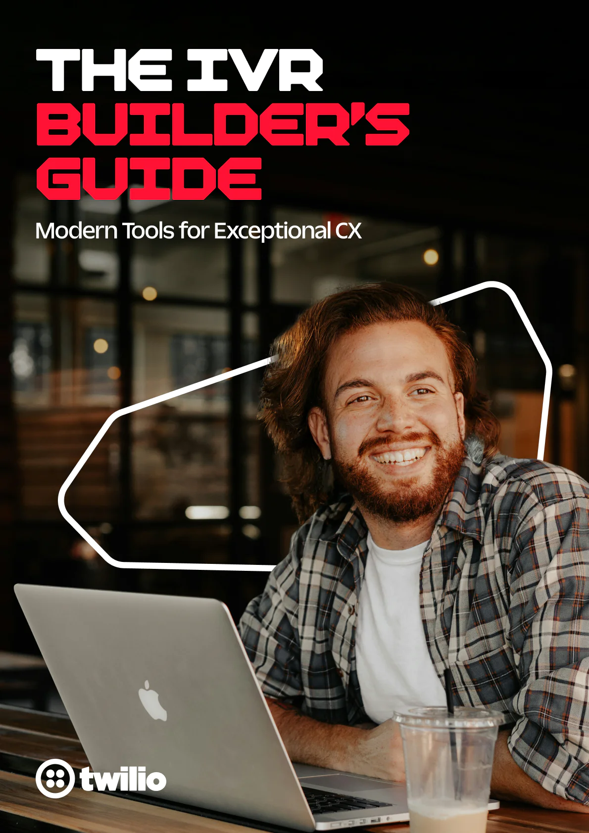 Man smiling at laptop with a drink nearby, cover of The IVR Builder's Guide by Twilio.
