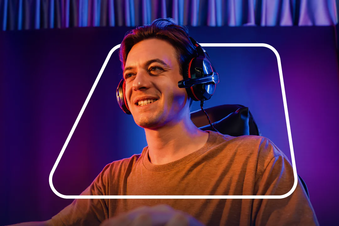 Man wearing a headset, smiling, and looking at a screen, with a purple and blue background.