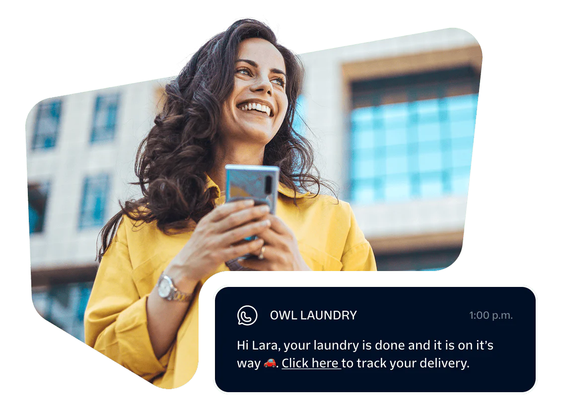 Smiling woman holding phone with a message notification from Owl Laundry.