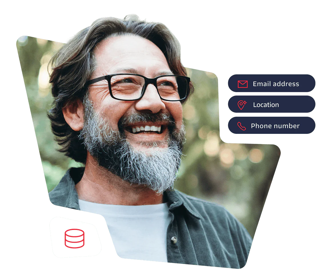 Smiling man with glasses and beard standing outdoors in a forest background.