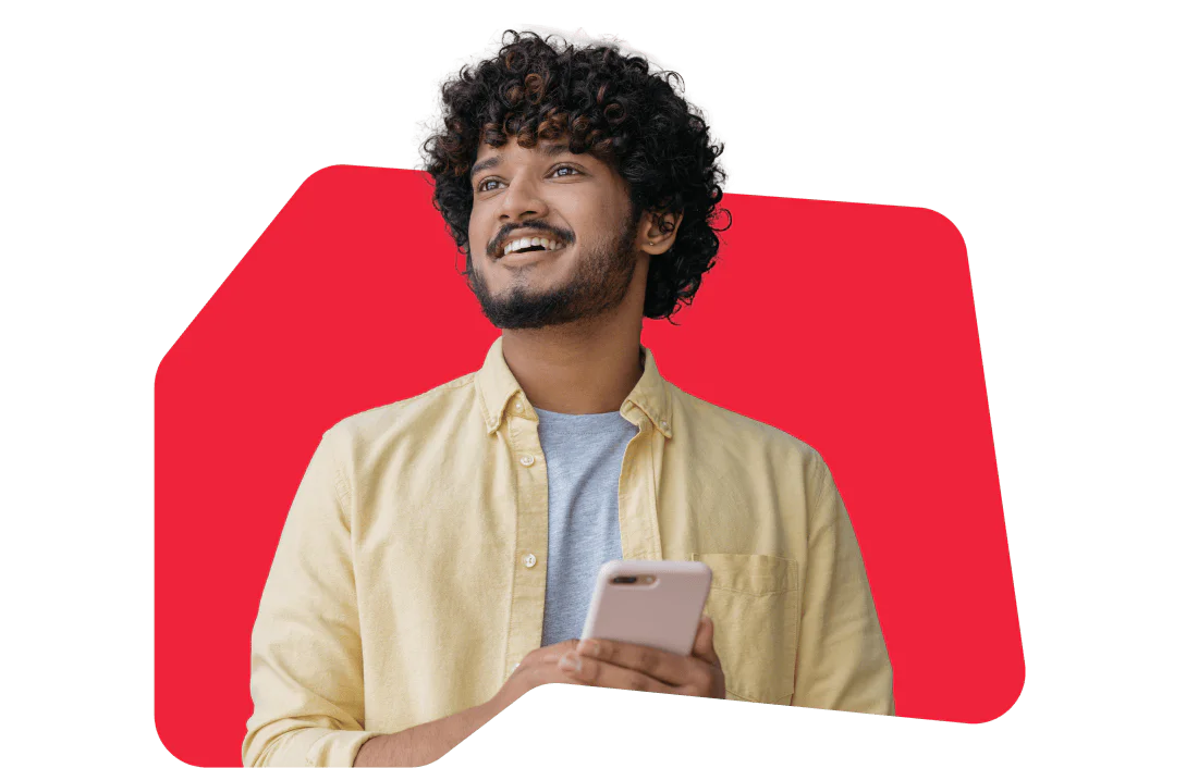 Smiling Man Talking on the Phone A smiling man holding a phone to his ear, wearing a dark jacket and green shirt with a red background.