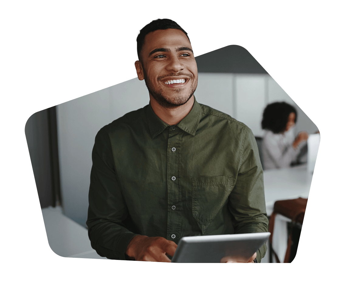 A man with short hair and a beard, wearing a green shirt, smiling against a red background.