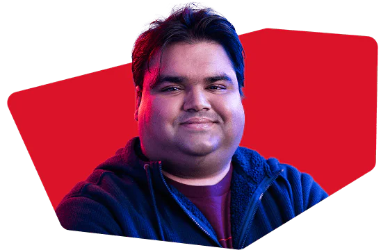 Portrait of a smiling man against a red background with blue and red lighting.