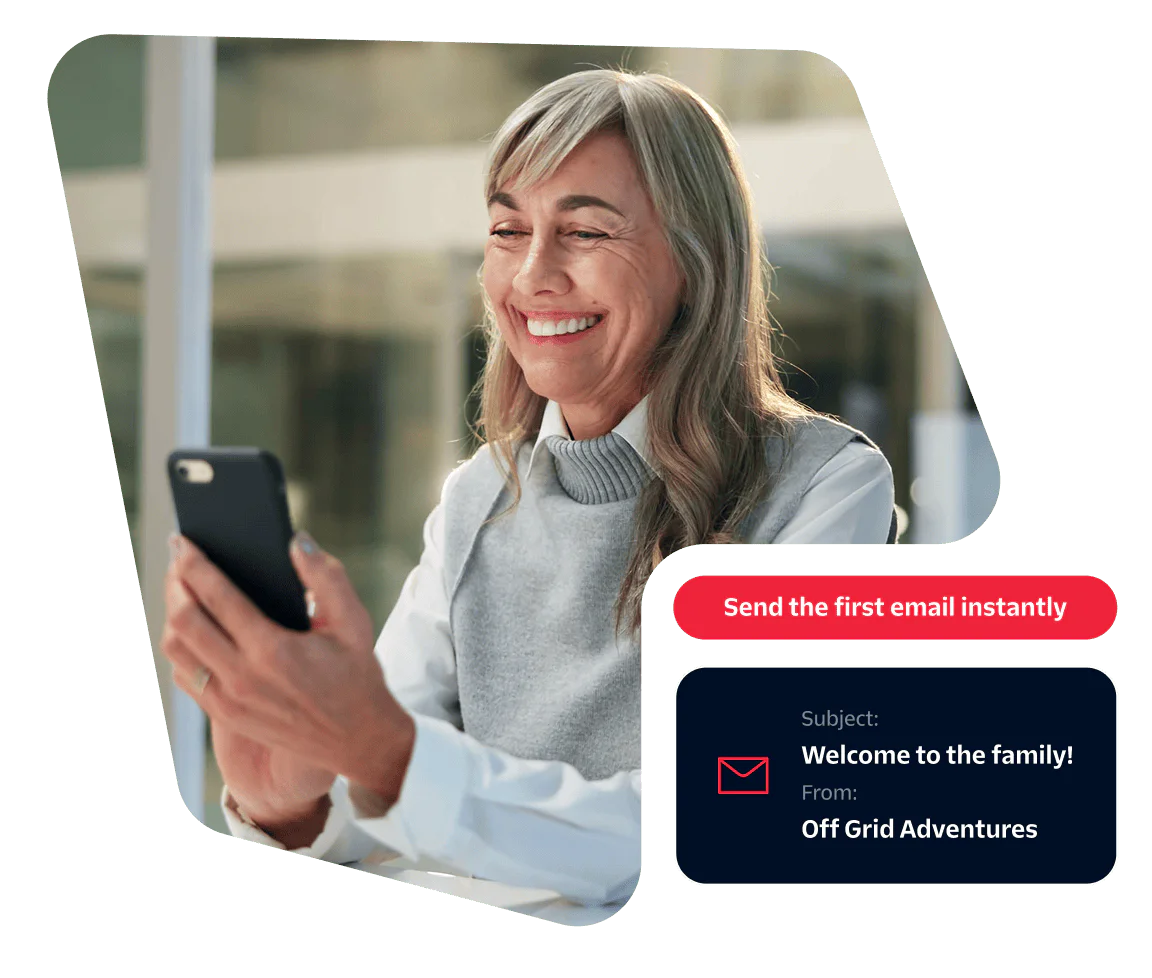 Smiling older woman using a smartphone with a pop-up message prompt to send the first email instantly.