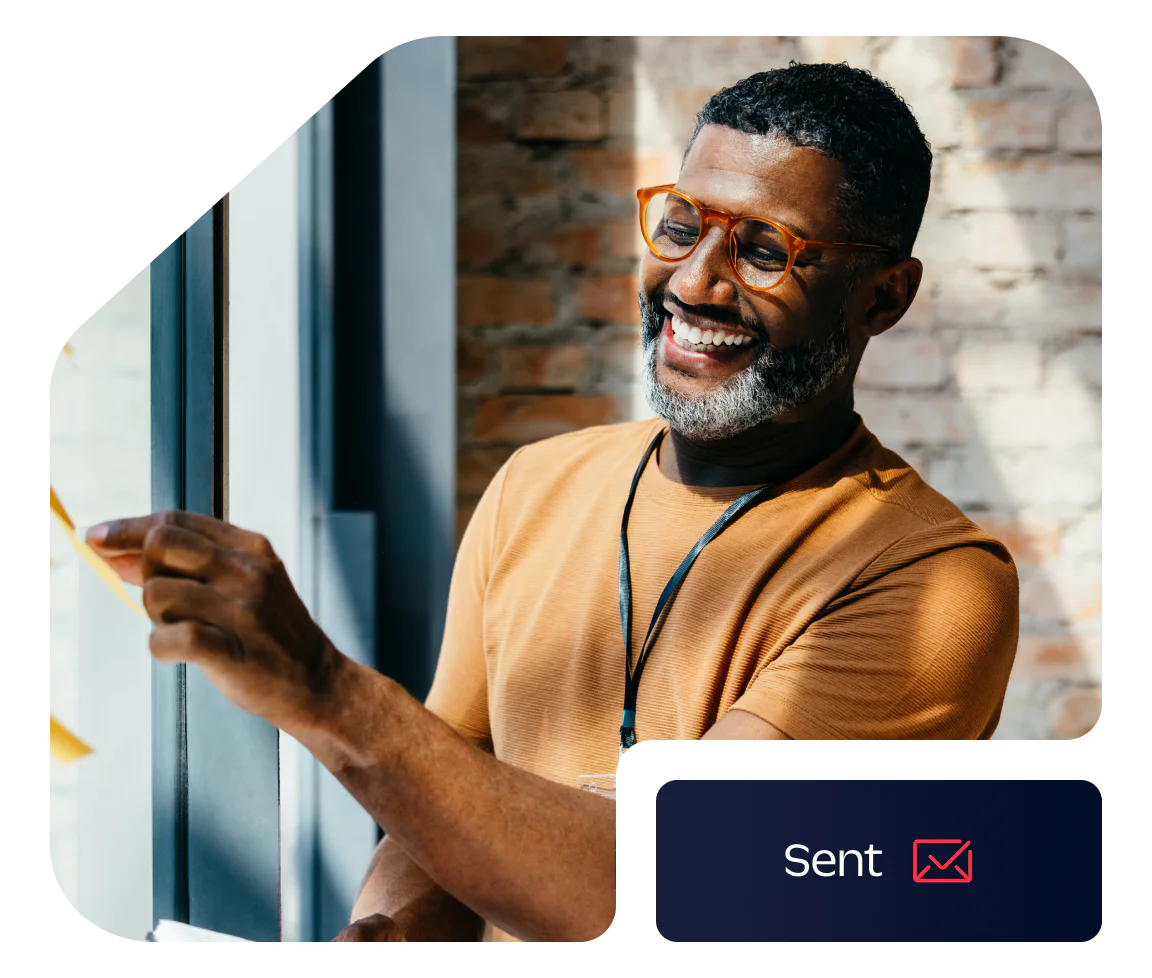 Smiling man with glasses sticking a note on a window