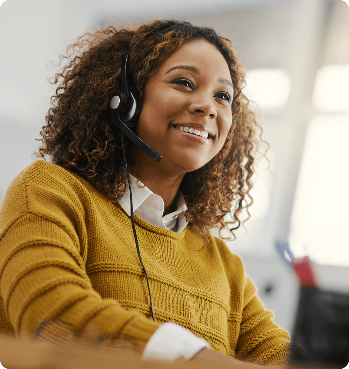 Woman with headset smiling in an office setting