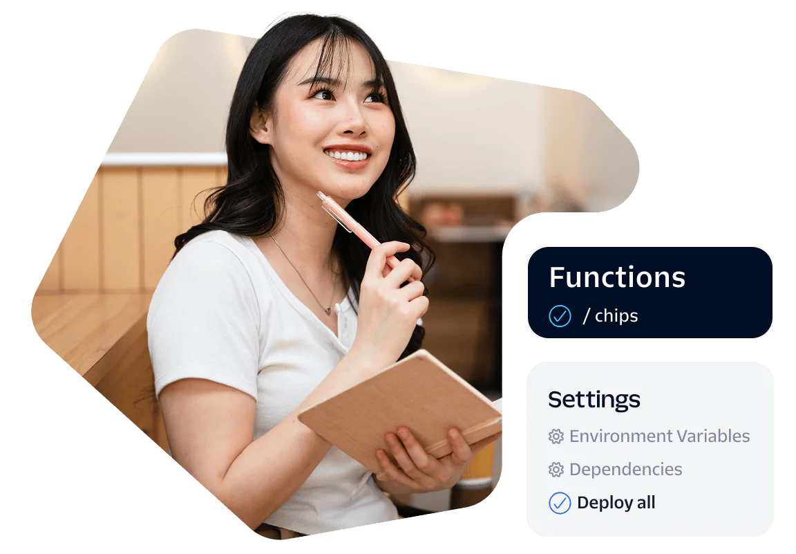 Woman holding a notebook and pen, sitting in a workspace with development settings on the side.