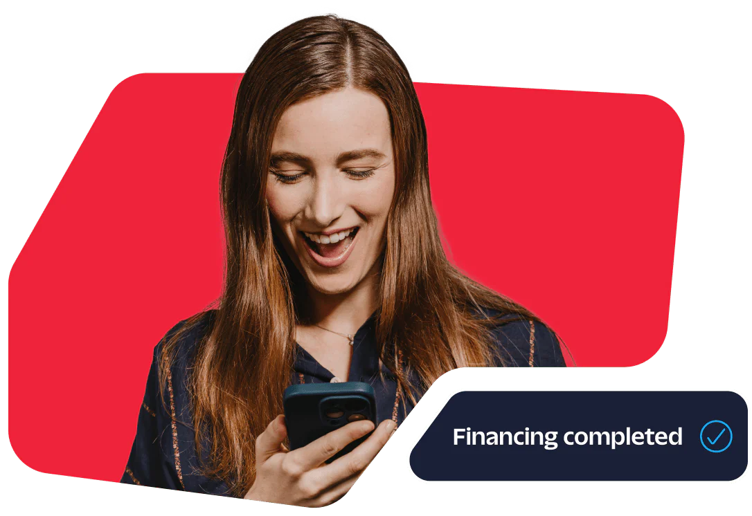 Smiling woman looking at her phone with Financing completed notification.