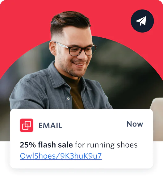 Smiling man with glasses reading an email about a 25% flash sale on running shoes.