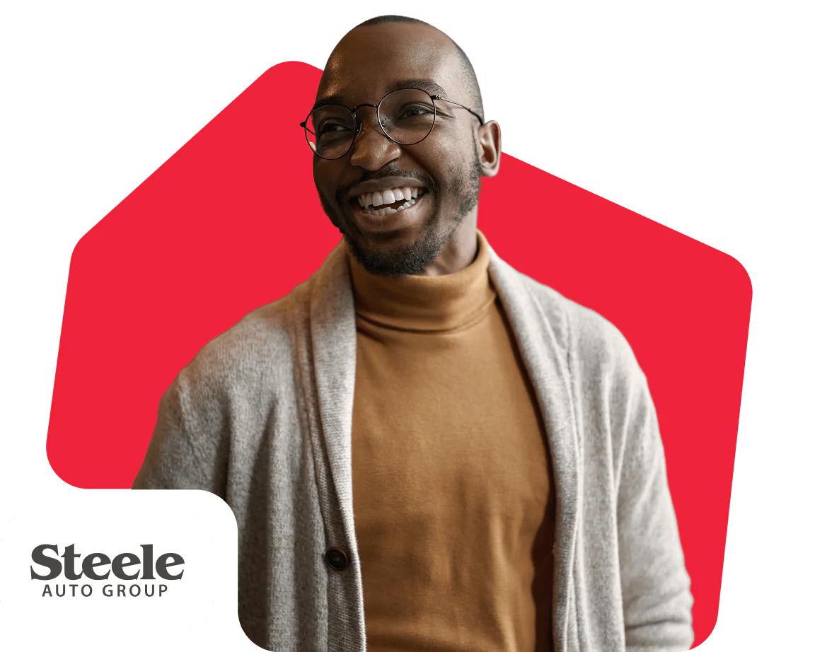 Man wearing glasses and a sweater smiling, with Steele Auto Group logo in the corner