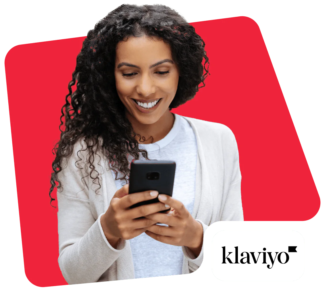 Smiling woman looking at smartphone with Klaviyo logo in the corner.