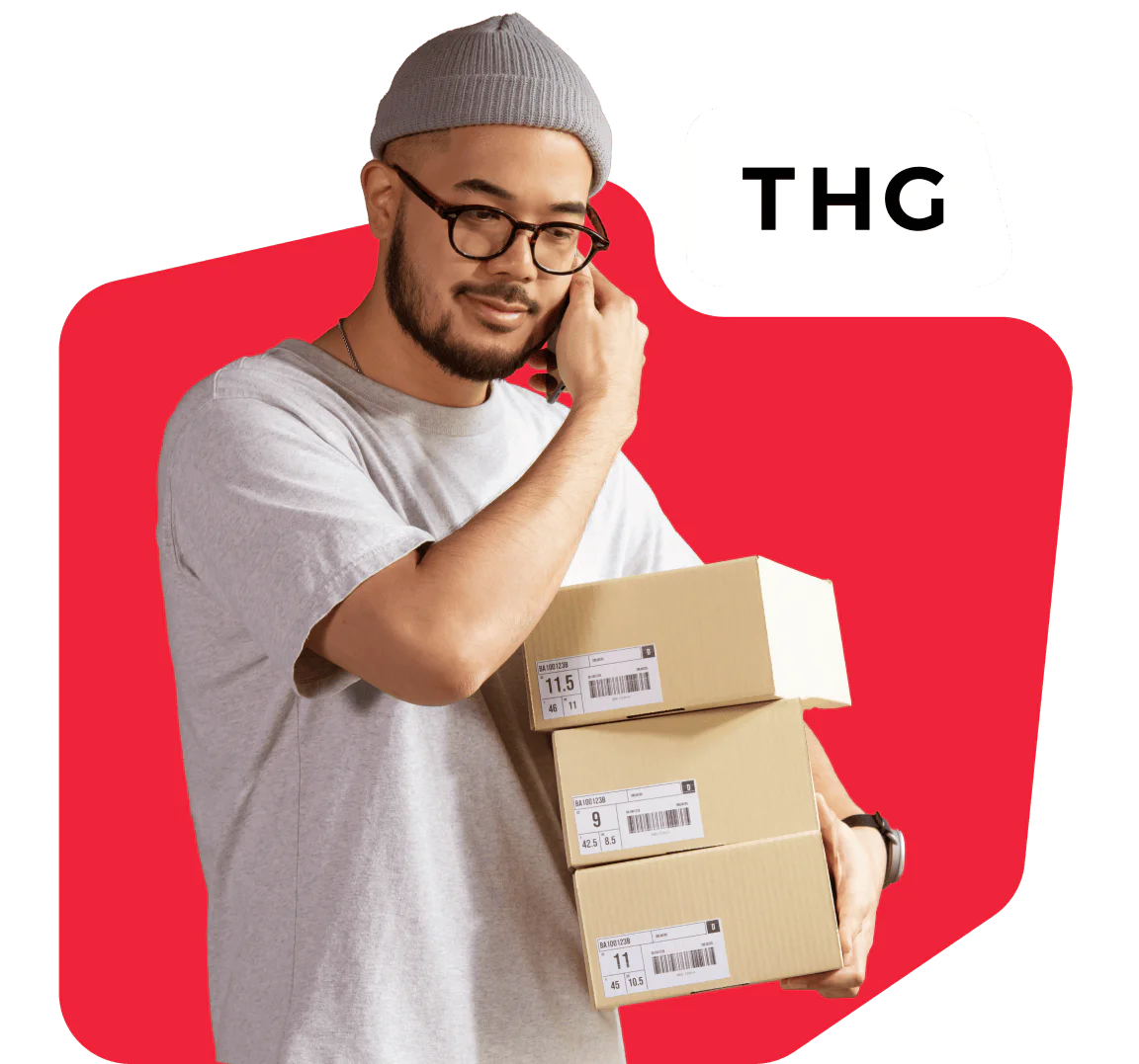 Man in grey beanie and glasses holding packages with THG logo on red background.
