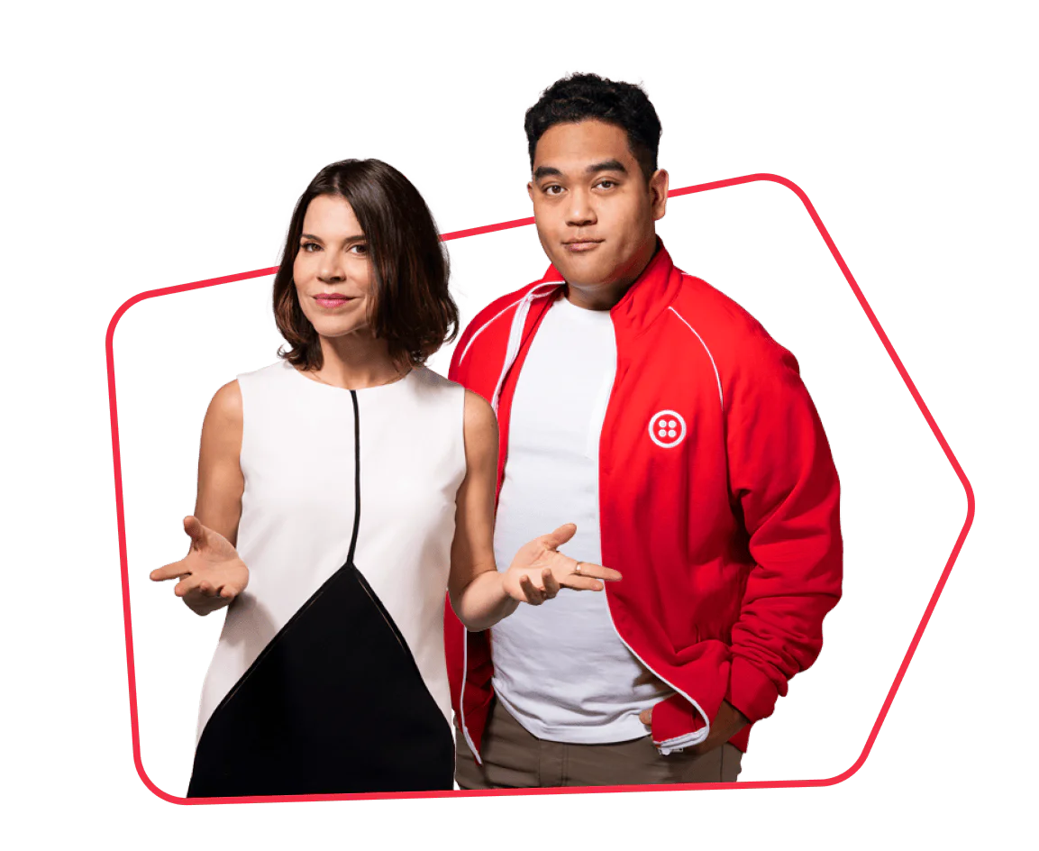 A woman in a white dress and a man in a red jacket posing together