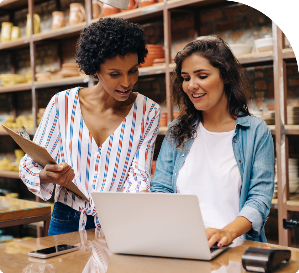 Two people looking at a laptop in a ceramics store