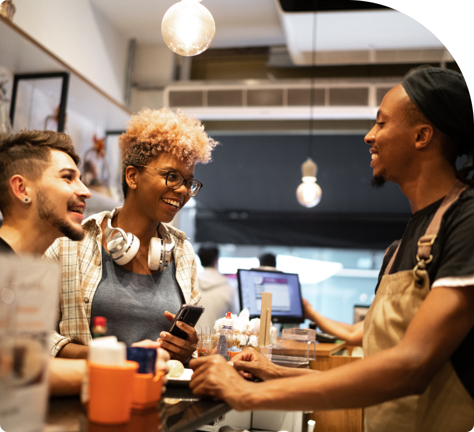 Three people at a coffee shop smiling