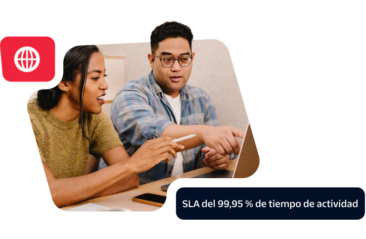 Two colleagues discussing work at a laptop showcasing a commitment to 99.95% uptime SLA