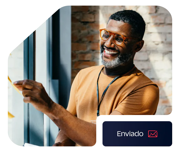 Smiling man with glasses sticking a note on a window