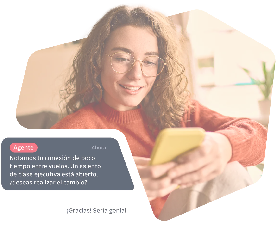 Woman smiles while reading a phone, screen shows a chat offering a business class seat upgrade.