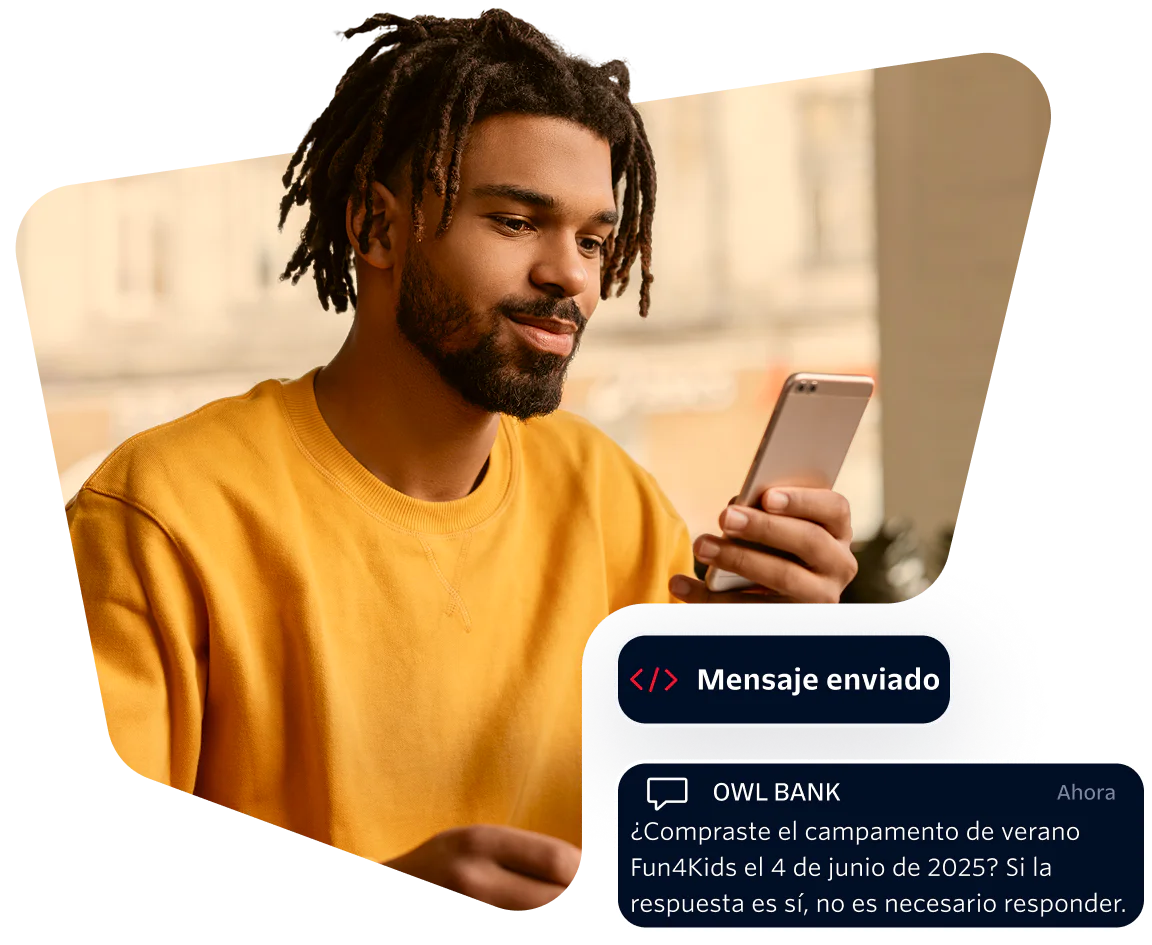 Man in yellow shirt looking at phone with a message from Owl Bank about a summer camp purchase.