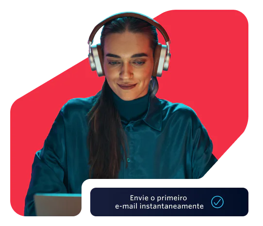 Woman wearing headphones working on her laptop Woman in headphones using a laptop with a prompt to send the first email instantly