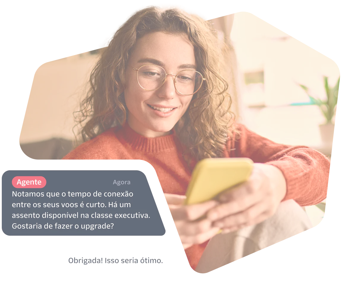 Woman smiles while reading a phone, screen shows a chat offering a business class seat upgrade.