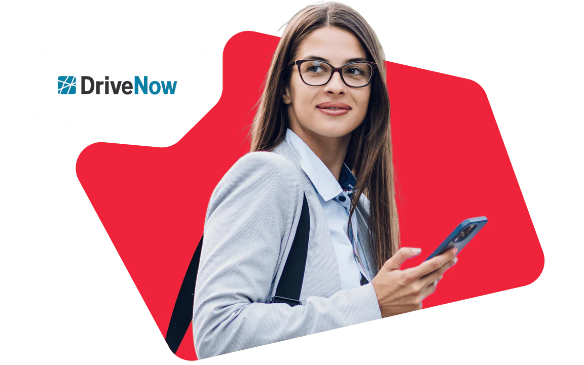 Woman with glasses using a smartphone and smiling with DriveNow logo in the background.